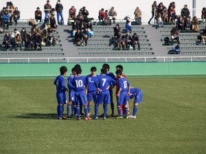 試合前の円陣を組む横河武蔵野FCの選手